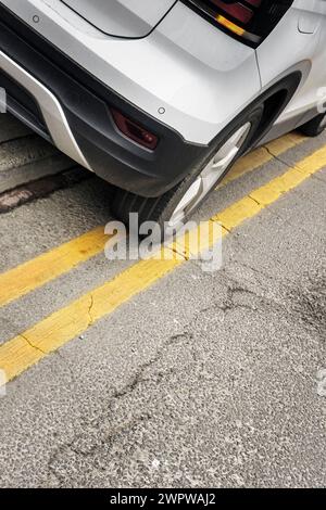 Un véhicule stationné sur les doubles lignes jaunes et la chaussée au Royaume-Uni. Banque D'Images