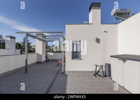 Grenier d'une maison unifamiliale avec des sols clairs, un auvent sans auvent et des sols en grès gris Banque D'Images