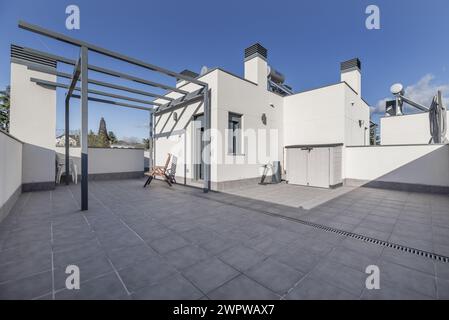 Grenier d'une maison unifamiliale avec sols clairs, auvent sans auvent, sol en grès gris sur une journée avec un ciel clair Banque D'Images