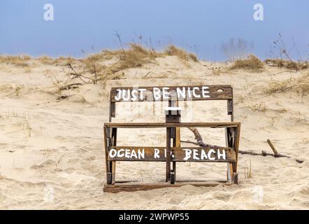 Un banc brut à Ocean Road Beach avec un message pour être juste agréable Banque D'Images