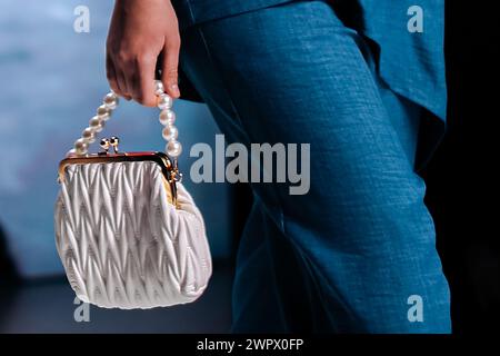 Gros plan sur les détails à la mode d'une pochette blanche avec des perles dans la main d'une femme. Vêtements et accessoires élégants Banque D'Images