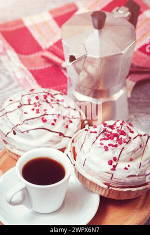 Les Cinnabons doux frais avec glaçage au sucre blanc et tasse de café blanc. Petit déjeuner confortable avec pâtisserie dessert. Banque D'Images