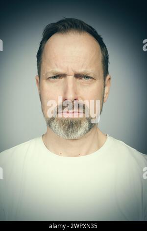 Portrait de l'homme vieillissant essayant des expressions en studio Banque D'Images