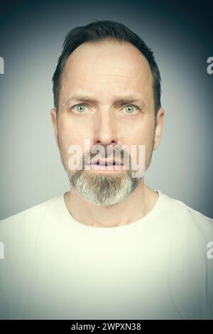 Portrait de l'homme vieillissant essayant des expressions en studio Banque D'Images