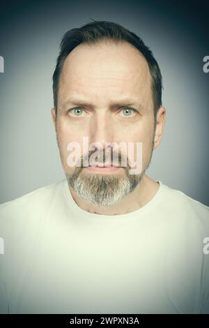 Portrait de l'homme vieillissant essayant des expressions en studio Banque D'Images