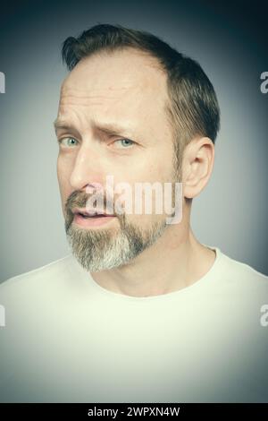 Portrait de l'homme vieillissant essayant des expressions en studio Banque D'Images