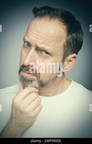 Portrait de l'homme vieillissant essayant des expressions en studio Banque D'Images