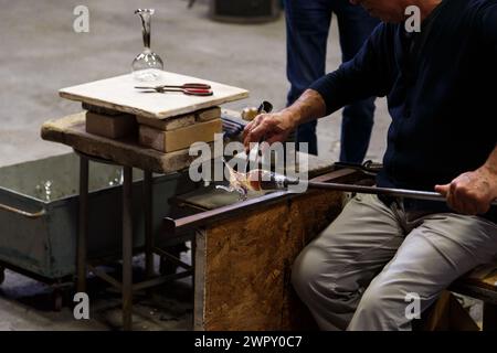 Île de Murano, Italie - 6 octobre 2019 : production manuelle de verre de Murano à l'usine de soufflage de verre. Verrerie travaillant avec une pièce de verre fondu Banque D'Images