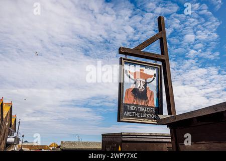 Amusant signe peint en bois avec Barbe Noire et 'Them that dies are the Lucky Ones' dans le stade de la vieille ville de Hastings, East Sussex, Angleterre Banque D'Images