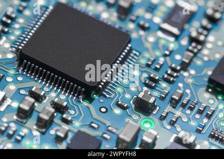 Gros plan d'une carte de circuit imprimé avec un processeur et divers éléments en rétroéclairage. Banque D'Images
