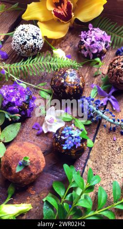 Boules faites à la main de grains de lin sur des feuilles de plantes vertes. Boules de bonbons naturels sur une table en bois gros plan. Banque D'Images