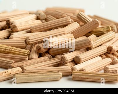 Gros plan d'un tas de goupilles cannelées en bois isolées sur un fond blanc Banque D'Images