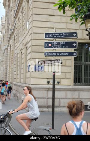 Une femme passe devant les panneaux de direction de la place Louis-Lépine, une place du 4e arrondissement de Paris sur l’île de la Cité Banque D'Images