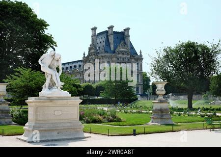 Une promenade parmi les sculptures, les parterres de fleurs et les chaises vertes du jardin Tuileries. Palais Royal - Musée du Louvre en toile de fond. Paris, France Banque D'Images