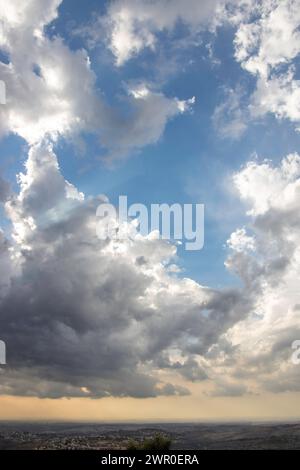 Spectaculaire spectacle du ciel : les rayons de soleil traversent des nuages de tempête majestueux au-dessus du paysage Banque D'Images