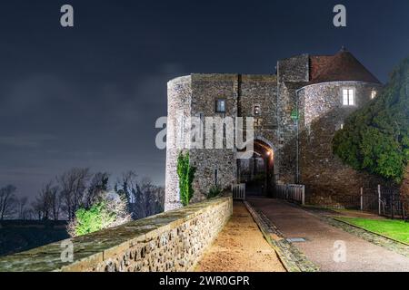 La porte défensive de Peverell, également connue sous le nom de tour de Peverell, une porte du XIIIe siècle avec tourelle, construite dans le mur saxon, illuminée la nuit. Banque D'Images