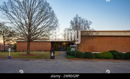 Prattville, Alabama, États-Unis-6 mars 2024 : extérieur de la bibliothèque publique d'Autauga-Prattville au coucher du soleil vu depuis le parking. Banque D'Images