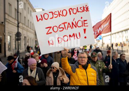 Un homme tient une pancarte indiquant "L'armée polonaise reste à la maison" lors d'un rassemblement anti-guerre le 9 mars 2024 à Varsovie, en Pologne. Plusieurs dizaines de personnes y ont participé Banque D'Images