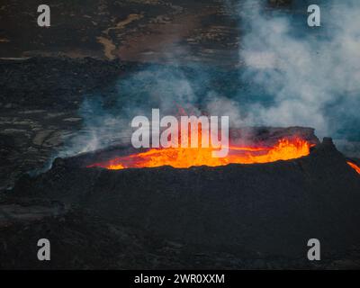 Vue unique sur le volcan en éruption et ses environs, lave rouge bouillante coulant, tir de drone. Catastrophe naturelle, environnement et climat ch Banque D'Images