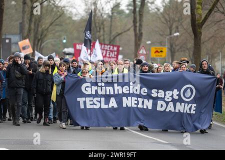 10 mars 2024, Brandebourg, Grünheide : lors d'une manifestation contre l'expansion de Tesla sous le slogan "Tesla non merci!", les participants portent une bannière avec l'inscription "Grünheide dit Tesla non merci". Photo : Christophe Gateau/dpa Banque D'Images