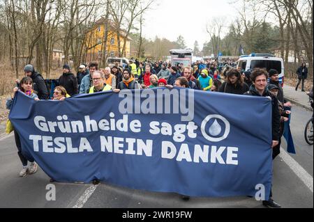 10 mars 2024, Brandebourg, Grünheide : lors d'une manifestation contre l'expansion de Tesla sous le slogan "Tesla non merci!", les participants portent une bannière avec l'inscription "Grünheide dit Tesla non merci". Photo : Christophe Gateau/dpa Banque D'Images