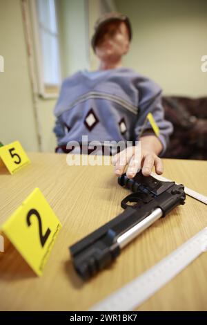 Aschersleben, Allemagne. 05 mars 2024. Une arme à feu et des marqueurs de preuves reposent sur une table à des fins de formation dans un « appartement sur scène de crime » à l'académie de police. Un nouveau centre de formation médico-légale pour les criminologues en herbe a été créé à l'académie de police d'Aschersleben. Crédit : Matthias Bein/dpa/Alamy Live News Banque D'Images