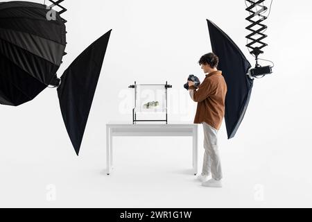 Photographe prend des photos professionnelles de baskets vertes en studio Banque D'Images