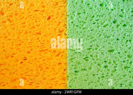 Éponges colorées orange et vertes pour lave-vaisselle avec texture de pores pour des graphiques de fond. Gros plan macro photo de deux tissus éponges domestiques. Banque D'Images