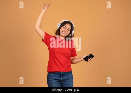 Joyeuse jeune femme du moyen-Orient écoutant de la musique Banque D'Images