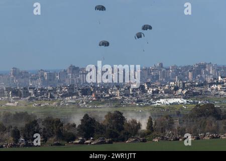 Sud d'Israël, Israël. 10 mars 2024. Ce que l'on pense être un C-130 de l'armée de l'air américaine lâche de l'aide humanitaire en parachute au-dessus du nord de la bande de Gaza vu de l'intérieur du sud d'Israël le 10 mars 2024. Les États-Unis et d'autres pays continuent de distribuer de la nourriture et d'autres fournitures d'aide humanitaire aux Palestiniens dans le besoin dans la bande de Gaza juste avant le début du mois sacré islamique du Ramadan alors que la guerre d'Israël contre le Hamas se poursuit. Photo de Jim Hollander/UPI crédit : UPI/Alamy Live News Banque D'Images