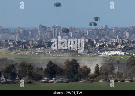 Sud d'Israël, Israël. 10 mars 2024. Ce que l'on pense être un C-130 de l'armée de l'air américaine lâche de l'aide humanitaire en parachute au-dessus du nord de la bande de Gaza vu de l'intérieur du sud d'Israël le 10 mars 2024. Les États-Unis et d'autres pays continuent de distribuer de la nourriture et d'autres fournitures d'aide humanitaire aux Palestiniens dans le besoin dans la bande de Gaza juste avant le début du mois sacré islamique du Ramadan alors que la guerre d'Israël contre le Hamas se poursuit. Photo de Jim Hollander/UPI crédit : UPI/Alamy Live News Banque D'Images