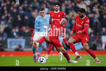 Phil Foden de Manchester City (à gauche) et Alexis Mac Allister de Liverpool se battent pour le ballon lors du match de premier League à Anfield, Liverpool. Date de la photo : dimanche 10 mars 2024. Banque D'Images