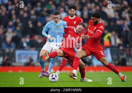 Phil Foden de Manchester City (à gauche) et Alexis Mac Allister de Liverpool se battent pour le ballon lors du match de premier League à Anfield, Liverpool. Date de la photo : dimanche 10 mars 2024. Banque D'Images