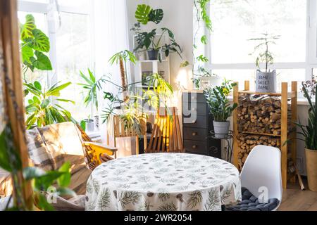 Table ronde vide pour l'installation et la démonstration du produit à l'intérieur avec des plantes tropicales d'intérieur dans la maison verte de pays. Plante d'intérieur cultivant Banque D'Images