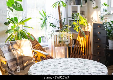 Table ronde vide pour l'installation et la démonstration du produit à l'intérieur avec des plantes tropicales d'intérieur dans la maison verte de pays. Plante d'intérieur cultivant Banque D'Images