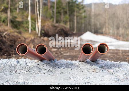 Tuyaux d'eaux usées en plastique orange posés sur le chantier de construction Banque D'Images