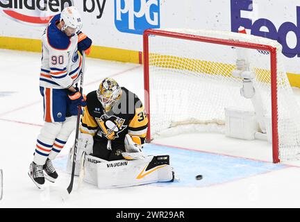 Pittsburgh, États-Unis. 10 mars 2024. Le gardien des Penguins de Pittsburgh, Tristan Jarry (35 ans), remet le palet à Corey Perry (90 ans), l'aile droite des Oilers d'Edmonton, en deuxième période au PPG Paints Arena de Pittsburgh, le dimanche 10 mars 2024. Photo par Archie Carpenter/UPI. Crédit : UPI/Alamy Live News Banque D'Images