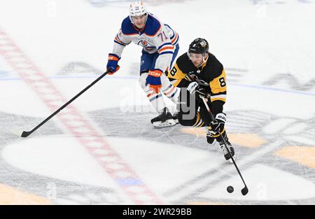 Pittsburgh, États-Unis. 10 mars 2024. Ryan McLeod (71 ans) suit les Penguins Micheal Bunting (8 ans) de Pittsburgh qui traversent le centre de la glace au cours de la deuxième période au PPG Paints Arena de Pittsburgh le dimanche 10 mars 2024. Photo par Archie Carpenter/UPI. Crédit : UPI/Alamy Live News Banque D'Images