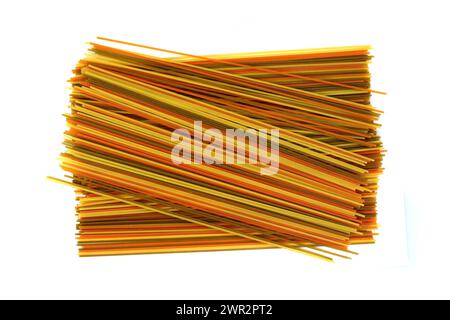 pâtes longues multicolores, spaghettis aromatisés isolés sur fond blanc. Pâtes fettuccine sèches non cuites attachées dans un faisceau isolé sur un blanc. Banque D'Images