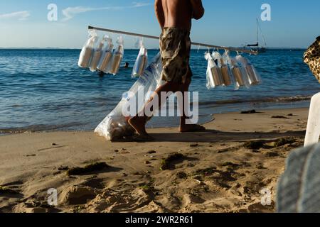 Salvador, Bahia, Brésil - 09 mars 2019 : vendeur de rue est vu marcher sur la plage de Ribeira dans la ville de Salvador, Bahia. Banque D'Images