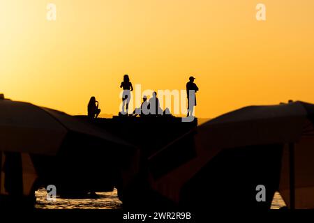 Salvador, Bahia, Brésil - 15 mars 2019 : des gens, en silhouette, sont vus sur la jetée de Porto da Barra en train de profiter du coucher de soleil dans la ville de Salvador, Bahi Banque D'Images