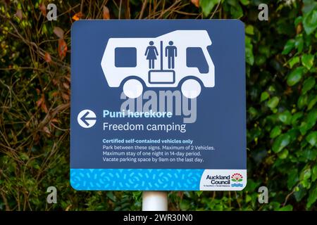 Māori et l'anglais bilingue Freedom Camping signe dans la communauté côtière de Maraetai, Tāmaki Makaurau / Auckland, te Ika-a-Maui / Île du Nord, Aotea Banque D'Images