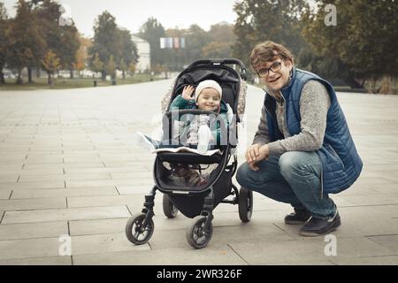 Couple de père et fils en poussette dans le parc d'automne Banque D'Images