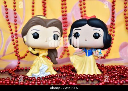 Figurines Funko Pop des princesses Disney belle (belle et la Bête) et Blanche-neige. Rideau rose doré, collier rouge, fabuleux palais. Banque D'Images