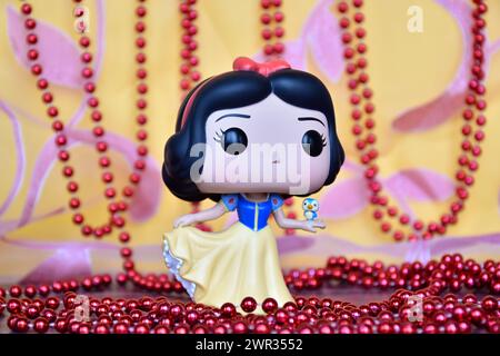 Funko Pop figurine de Disney princesse Blanche-neige avec oiseau. Rideau rose doré, décor collier rouge, fabuleux palais. Banque D'Images