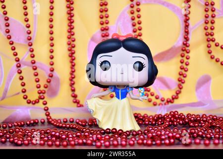 Funko Pop figurine de Disney princesse Blanche-neige avec oiseau. Rideau rose doré, décor collier rouge, fabuleux palais. Banque D'Images