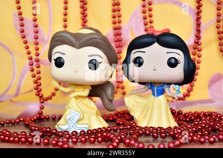 Figurines Funko Pop des princesses Disney belle (belle et la Bête) et Blanche-neige. Rideau rose doré, collier rouge, fabuleux palais. Banque D'Images