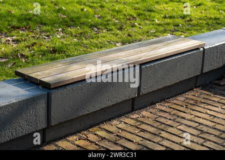 Banc en bois moderne sur une fondation en béton dans l'espace extérieur Banque D'Images