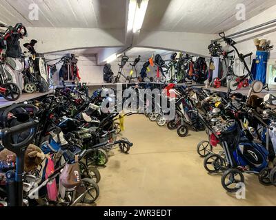 Chariot de golf avec sac de golf dans une salle illuminée en Suisse Banque D'Images