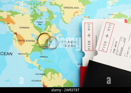 Concept de lune de miel. Billets d'avion, passeports et anneaux d'or sur la carte du monde, vue de dessus Banque D'Images